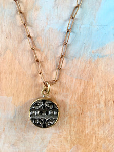 Antique button on a brass chain